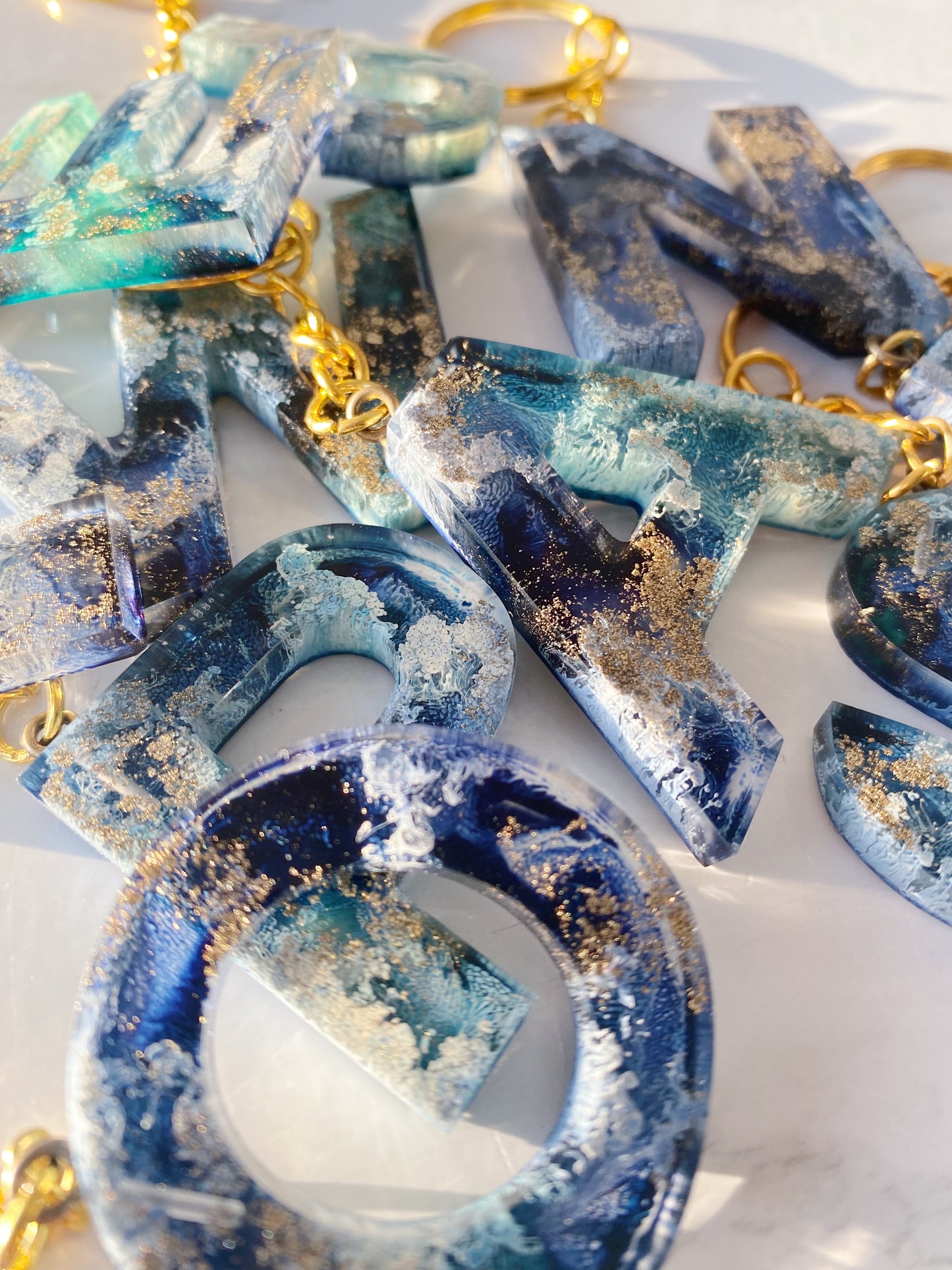 Schlüsselanhänger aus Kunstharz – Buchstaben in Navy Blau, Türkis, Gold und Weiß
