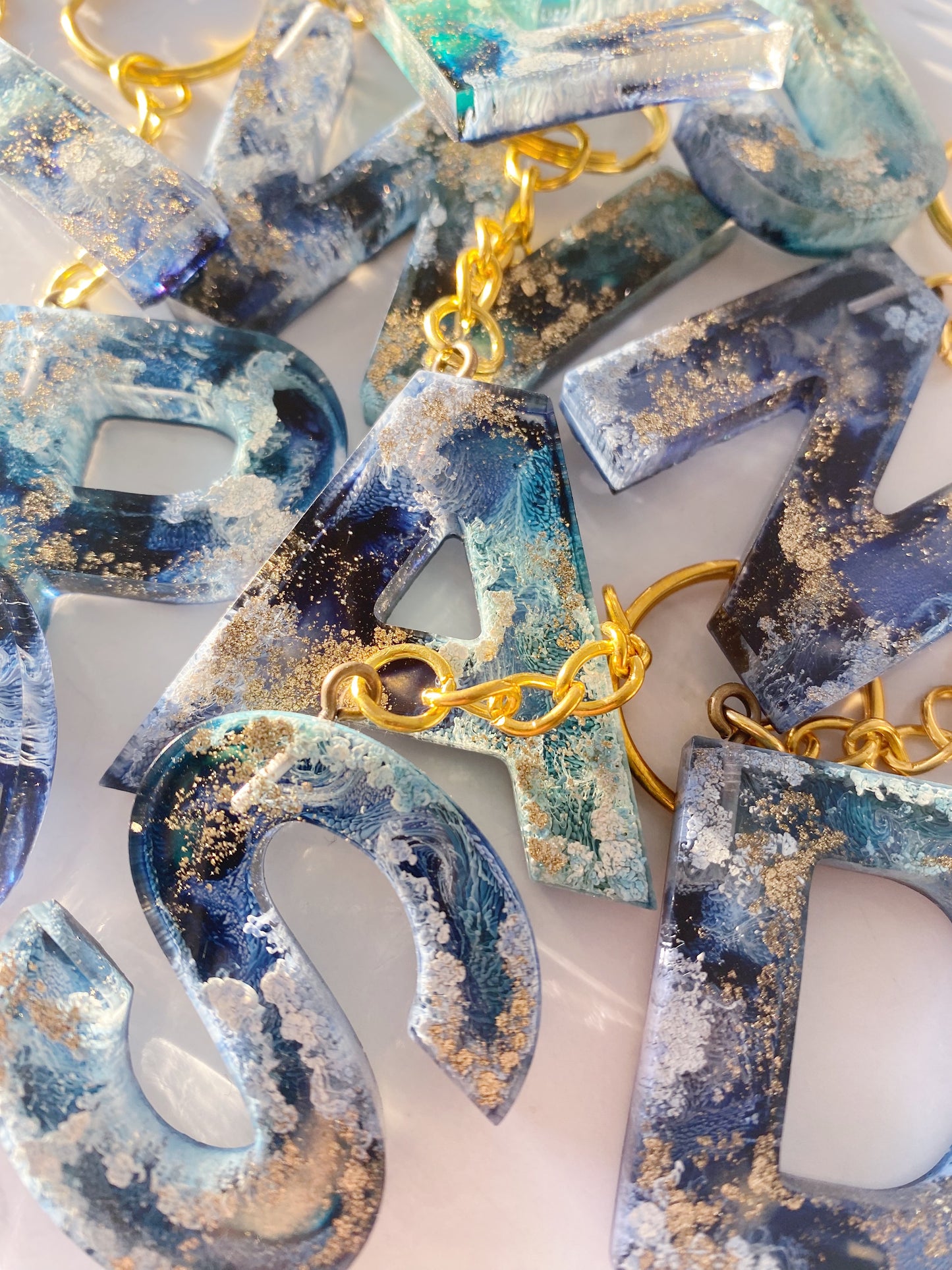 Schlüsselanhänger aus Kunstharz – Buchstaben in Navy Blau, Türkis, Gold und Weiß